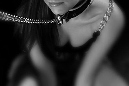 sumisa con collar de BDSM con cadena